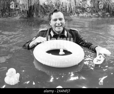 RICHARD BURTON on a studio set of a river with a toy boat, rubber ducks and swimming ring in a light-hearted moment during the filming of WHERE EAGLES DARE 1968 Director BRIAN G. HUTTON Story and screenplay ALISTAIR MacLEAN Music RON GOODWIN Gershwin-Kastner Productions / Winkast Film Productions / Metro Goldwyn Mayer Stock Photo