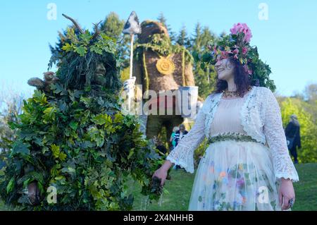 Richard (left) and Jenni Thompson, depicting the Green Man and May Queen, in front of a giant wicker man during the Beltain Celtic Fire Festival at Butser Ancient Farm, in Waterlooville, Hampshire. Picture date: Saturday May 4, 2024. Stock Photo