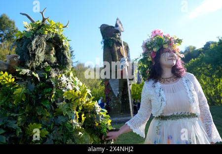 Richard (left) and Jenni Thompson, depicting the Green Man and May Queen, in front of a giant wicker man during the Beltain Celtic Fire Festival at Butser Ancient Farm, in Waterlooville, Hampshire. Picture date: Saturday May 4, 2024. Stock Photo