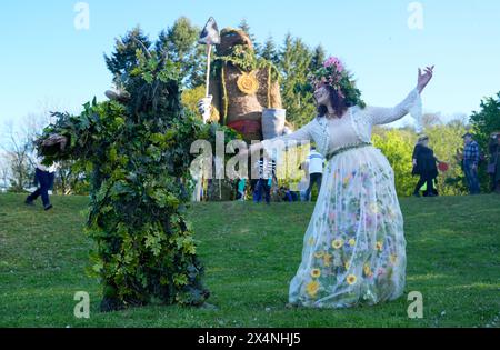 Richard (left) and Jenni Thompson, depicting the Green Man and May Queen, in front of a giant wicker man during the Beltain Celtic Fire Festival at Butser Ancient Farm, in Waterlooville, Hampshire. Picture date: Saturday May 4, 2024. Stock Photo