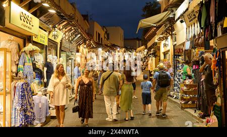 People strolling through a busy shopping street in the evening light, night shot, Rhodes Old Town, Rhodes, Dodecanese, Greek Islands, Greece Stock Photo