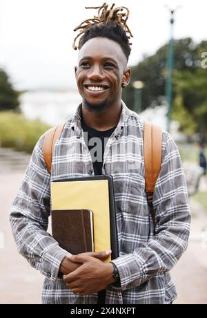 Student, college and black man, outdoor and books to study, smile and backpack for education. University, guy and happiness for scholarship, campus Stock Photo