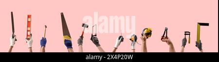Many hands holding construction tools on pink background Stock Photo