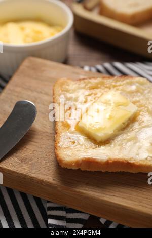 Melting butter, toast and knife on table, closeup Stock Photo