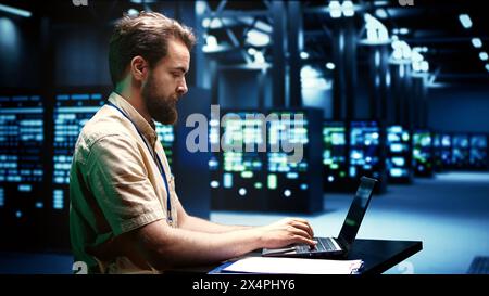 Expert running server hub diagnostic tests and error checking utilities to find and fix software problems. Engineer monitoring critical systems, checking for malfunctions Stock Photo