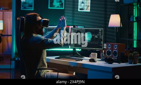 Ecstatic man celebrating after awakening AI using VR headset, making it ask existential questions. Happy developer excited to chat with artificial intelligence using virtual reality tech, camera A Stock Photo