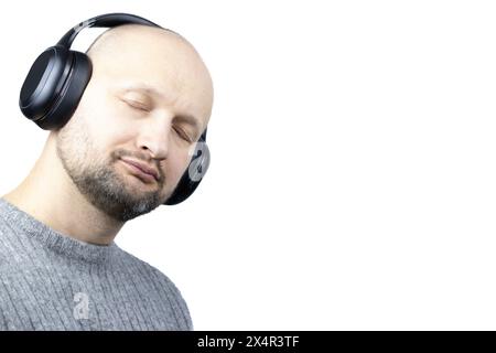 This is a captivating portrait of a man, set against a stark white background. He is clad in a finely knit grey wool sweater, his eyes closed Stock Photo