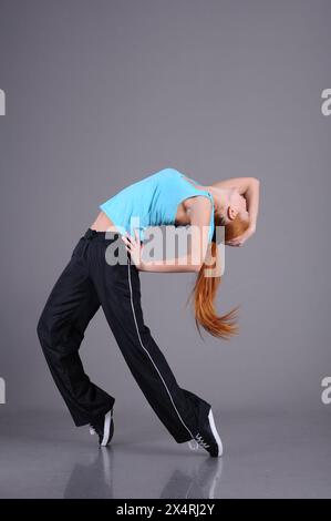 funky young woman dancing isolated on grey background Stock Photo