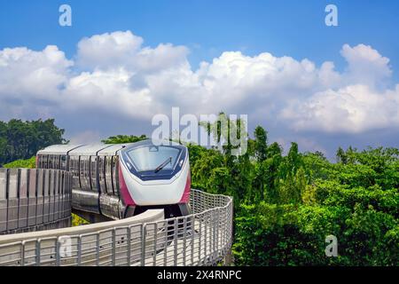 Monorail train race station on the stage road junction turn surrounded by city park and trees. Stock Photo