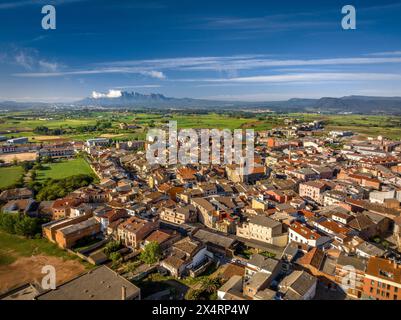 Aerial view of the town of Santpedor. In the background, the green fields of Pla de Bages and the Montserrat mountain (Barcelona, Catalonia, Spain) Stock Photo