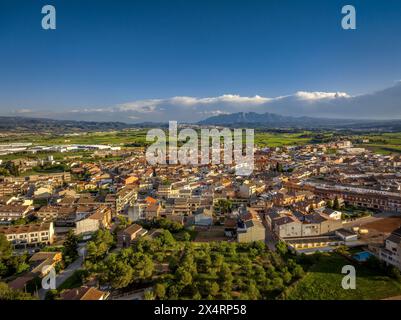 Aerial view of the town of Santpedor. In the background, the green fields of Pla de Bages and the Montserrat mountain (Barcelona, Catalonia, Spain) Stock Photo