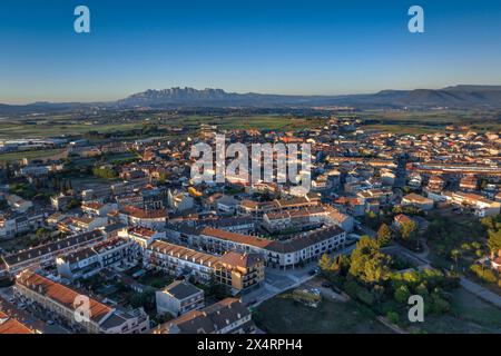 Aerial view of the town of Santpedor on a spring sunrise. In the background, the Montserrat mountain (Bages, Barcelona, Catalonia, Spain) Stock Photo