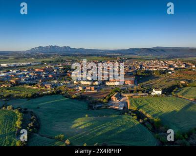 Aerial view of the town of Santpedor on a spring sunrise. In the background, the Montserrat mountain (Bages, Barcelona, Catalonia, Spain) Stock Photo