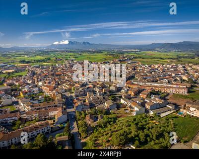 Aerial view of the town of Santpedor. In the background, the green fields of Pla de Bages and the Montserrat mountain (Barcelona, Catalonia, Spain) Stock Photo