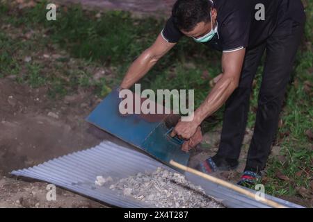 Phatthalung, Thailand- April 05, 2024: Undertakers perform rituals to deal with the ashes of the dead after they are cremated. According to Buddhist b Stock Photo