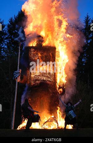 Members of the Pentacle Drummers perform in front of a burning wicker man during the Beltain Celtic Fire Festival at Butser Ancient Farm, near Waterlooville, Hampshire. Picture date: Saturday May 4, 2024. Stock Photo
