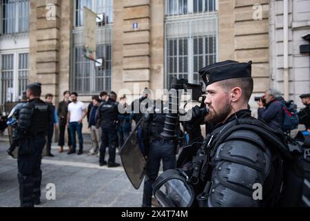 May 3rd 2024, Paris, France. A police officer holds a crowd control weapon while a pro-Israel group is questioned in the background after interrupting a pro-Palestine rally. Credit: Jay Kogler/Alamy Live News Stock Photo