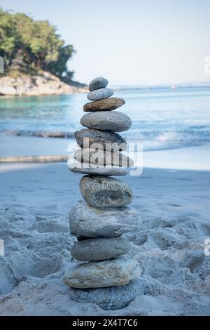 Stack stones on the coast of the sea in the nature. Cairn on the ocean beach, five pebbles tower. Concept of balance and harmony. Calm and spirit Stock Photo