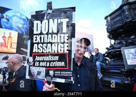 Protesters demonstrated outside Picadilly Circus Saturday afternoon demanding Julien Assange is set free as he is innocent and faces the death penalty just for speaking the truth . This also is a huge infringement freedom of the press if he is extradited .... Stock Photo