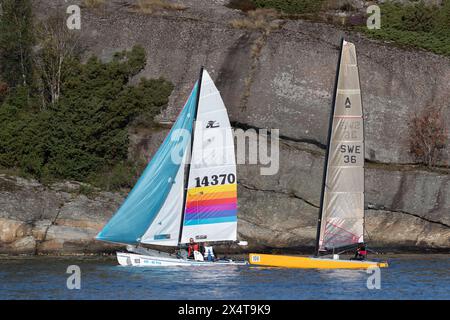 Stenungsund, Sweden - August 21 2021: Sailboats at sea in a sailing race. Rocky island in background. Crew visible on the boats. Stock Photo