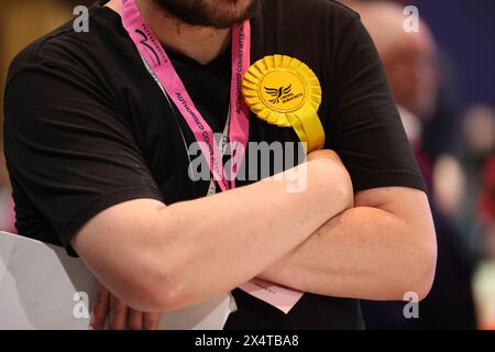 Peterborough, UK. 03rd May, 2024. A yellow Lib Dem (Liberal Democrats) rosette. Voting forms are in, and counting has begun at KingsGate Community Church in Peterborough, after voters went to the polling booths for the local council elections and election of the Police and Crime Commissioner for Cambridgeshire police area. Voters had to take photographic identification to the polling stations in Peterborough, Cambridgeshire, or they would not be able to vote. Local elections, Peterborough, Cambridgeshire, on 2nd May, 2024. Credit: Paul Marriott/Alamy Live News Stock Photo