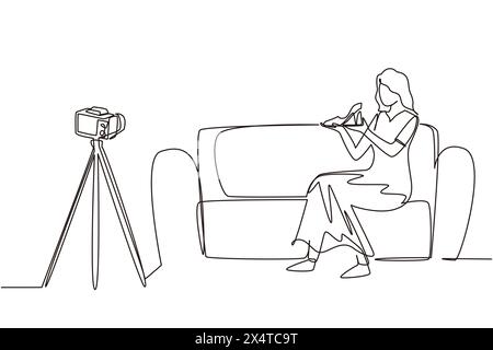 Single continuous line drawing stylish beauty blogger is sitting at sofa, reviewing heels shoe in her hands while recording video with digital camera, Stock Vector