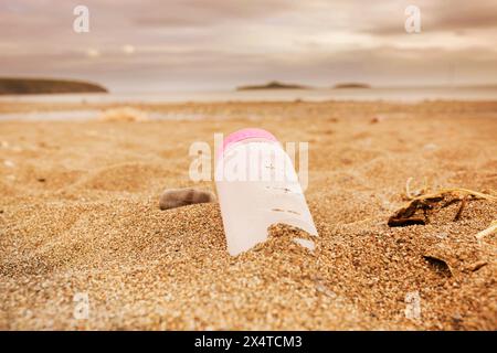 Plastic water bottle left discarded on a beach in Wales. Plastic waste in our oceans concept Stock Photo