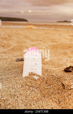 Plastic water bottle left discarded on a beach in Wales. Plastic waste in our oceans concept Stock Photo