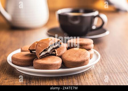 Close-Up View of Chocolate-Coated Sandwich Cookies on a wooden table. Stock Photo