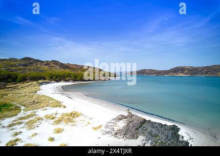 Silver Sands of Morar Highland Scotland blue sky over cove and sand beach with River Morar and sea at high tide Stock Photo
