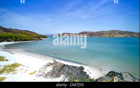 Silver Sands of Morar Highland Scotland blue sky over cove and sandy beach with River Morar and sea at high tide Stock Photo