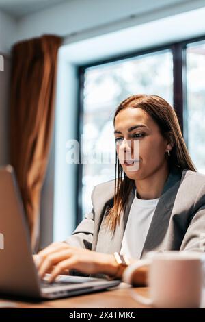 woman working in an office typing on the laptop Stock Photo