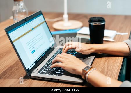 woman working in an office typing on the laptop Stock Photo