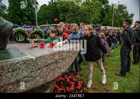 Nijmegen, Netherlands. 04th May, 2024. Children are seen leaving flowers at the war monument. On this day, the whole country commemorates civilians and soldiers during the World War II and other conflicts. In Nijmegen, a silent procession took the streets to the 'Keizer Traianusplein', where two monuments in remembrance of the victims of WWII stand up. The official ceremony started with two minutes of silence, and wreaths were laid. Credit: SOPA Images Limited/Alamy Live News Stock Photo