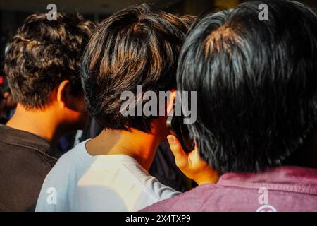 Rear view of a man making a phone call in the middle of a crowd Stock Photo