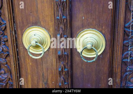Classic vintage golden door knobs. Antique door knobs with carvings on wooden door Stock Photo
