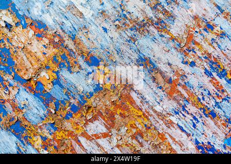 Minimalist colourful textured background of old and rusted whit, blue, brown and orange  paing on metallic surface, in direct sun light in an urban en Stock Photo
