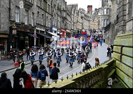 Edinburgh, Scotland, UK. 5th May 2024. The annual Edinburgh and Lothians May Day march, commencing at Johnston Terrace then marching down the Royal Mile to the Pleasance where there is a rally, music and stalls with various activist groups in attendance. March on Cockburn Street with the City of Edinburgh Pipes and Drums leading the way. Credit: Craig Brown/Alamy Live News Stock Photo