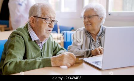 Senior people trying to shop online with laptop Stock Photo