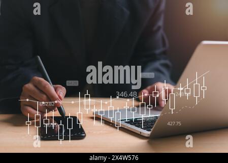A man is using a stylus to draw on a laptop screen. Concept of focus and concentration as the man works on his project. The laptop screen displays a g Stock Photo