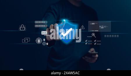 A person is touching a blue shield on a computer screen. The shield is a symbol of protection and cyber security Stock Photo