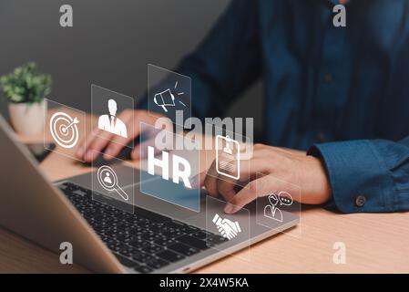 An HR manager engages with an interactive Human Resources management system on a laptop. Stock Photo