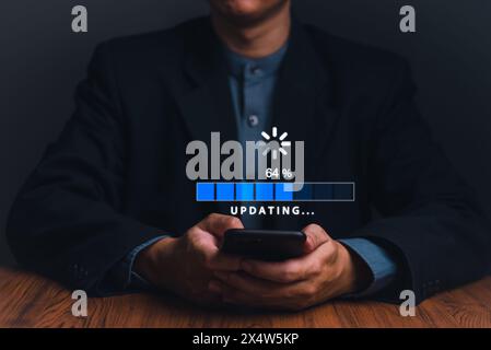 A user patiently awaits completion as a progress bar on a smartphone indicates a technology update. Stock Photo