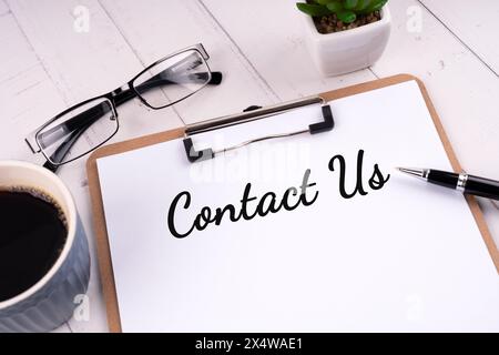 Contact us text on clipboard business concept Stock Photo