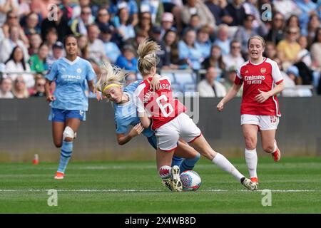 Manchester City's Chloe Kelly (centre left) is tackled by Arsenal's Leah Williamson during the Barclays Women's Super League match at the Joie Stadium, Manchester. Picture date: Sunday May 5, 2024. Stock Photo