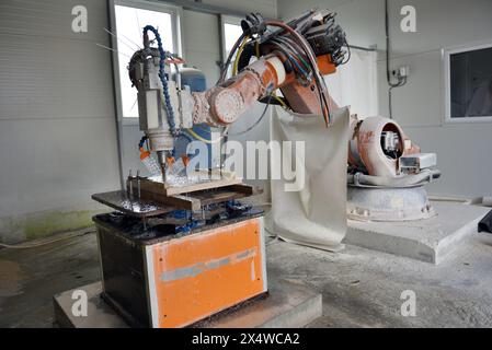 Robot working on milling sculpture in natural stone Stock Photo