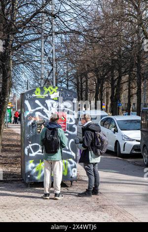 School boys reading a paste-up poster in Aleksis Kiven katu. Helsinki, Finland. Stock Photo