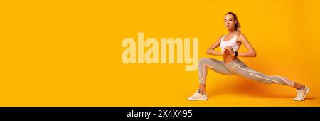 Lady Doing Deep Lunge Exercise Over Yellow Background Stock Photo