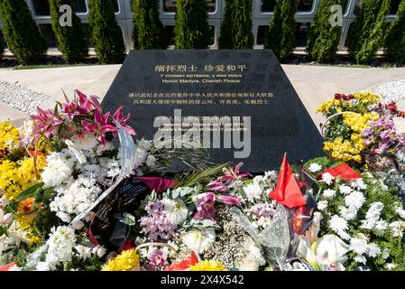 Flowers and Chinese flags respectfully laid at the memorial to the former Chinese embassy bombed in Belgrade in 1999. April 2024. Stock Photo