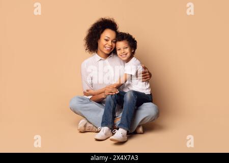 Woman and Child Sitting on the Ground, Embracing Stock Photo